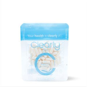 Bottle of Clearly Zinc dietary supplement with capsules on a clean surface, showcasing the supplement's packaging.